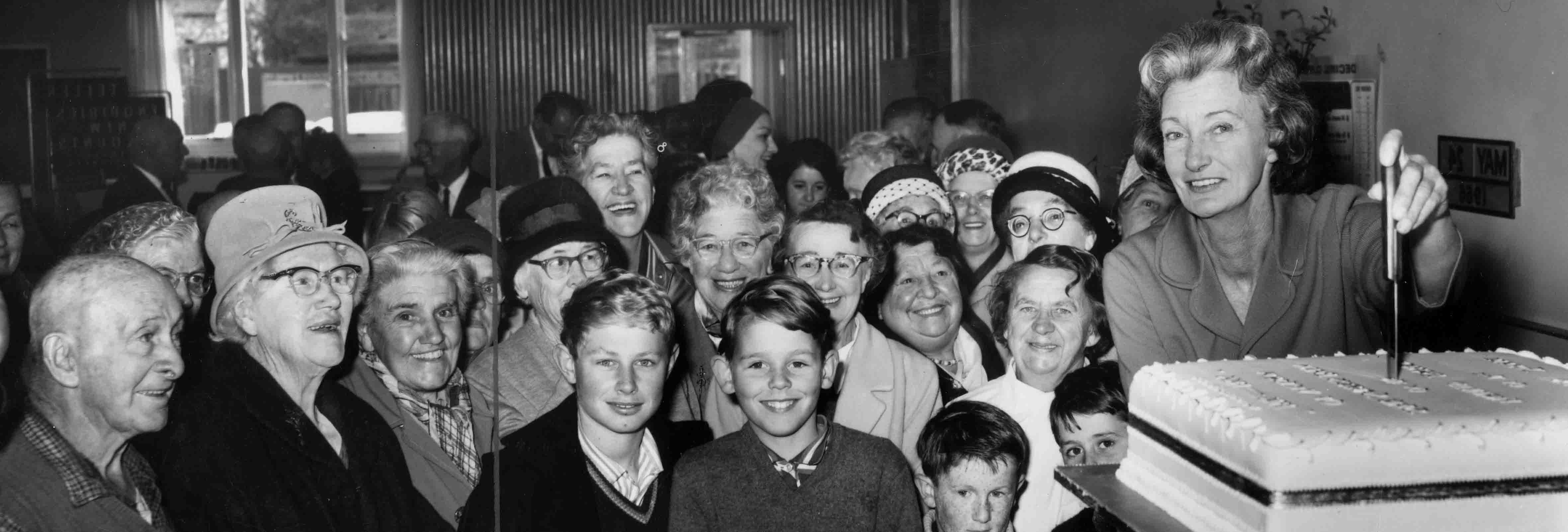 Black and white photo, crowd with a cake