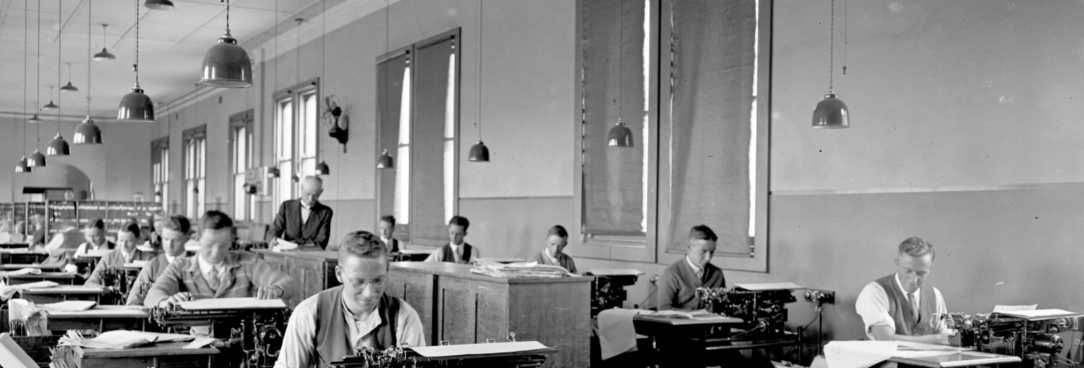 Black and white photo of people sitting at desks