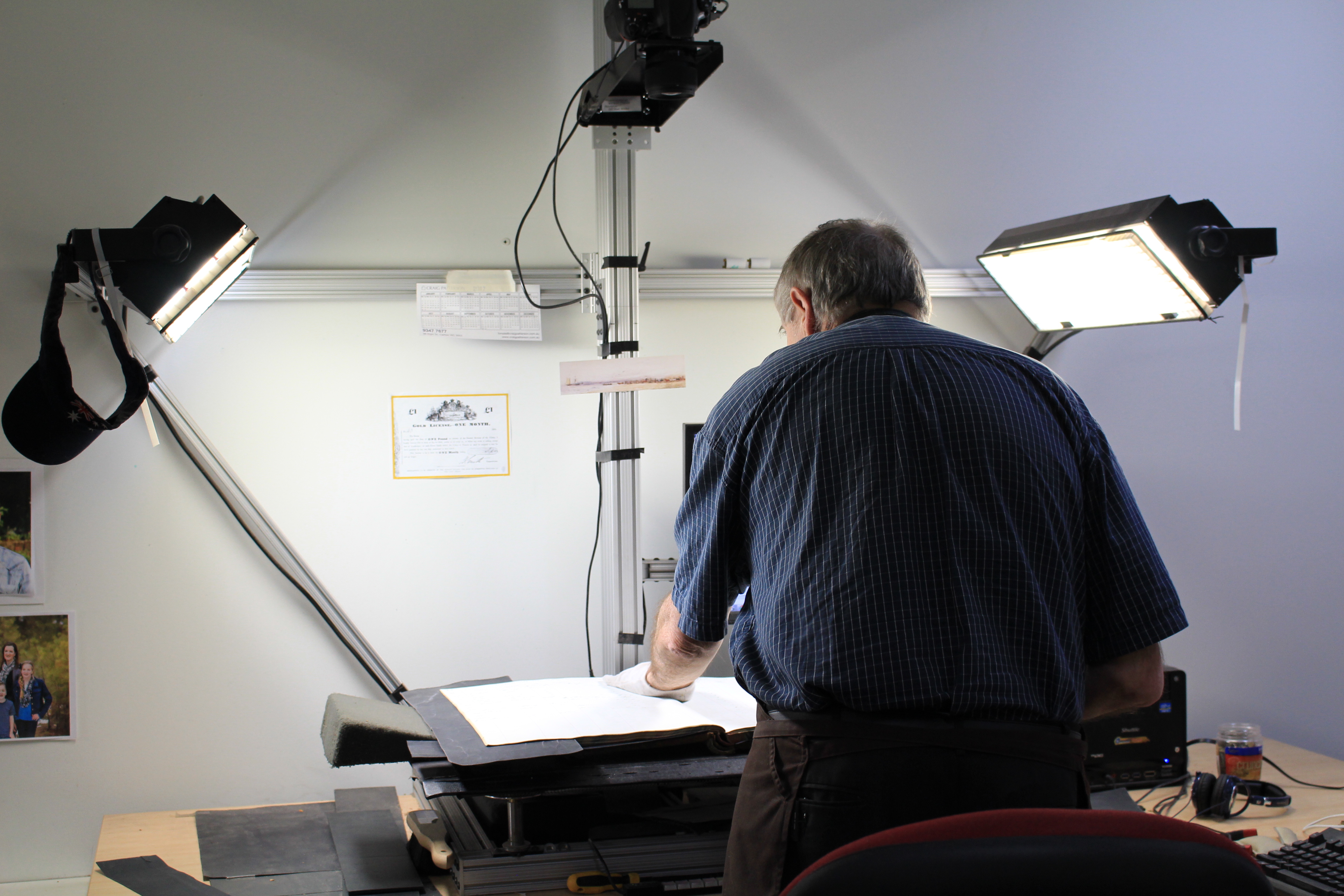 Photo of a man photographing a rate book using special scanning equipment