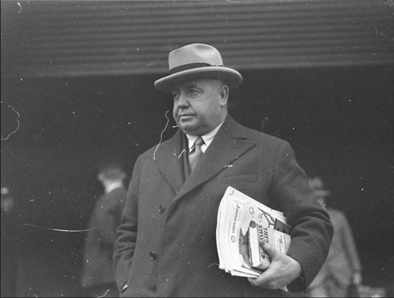 Photo of man holding newspapers