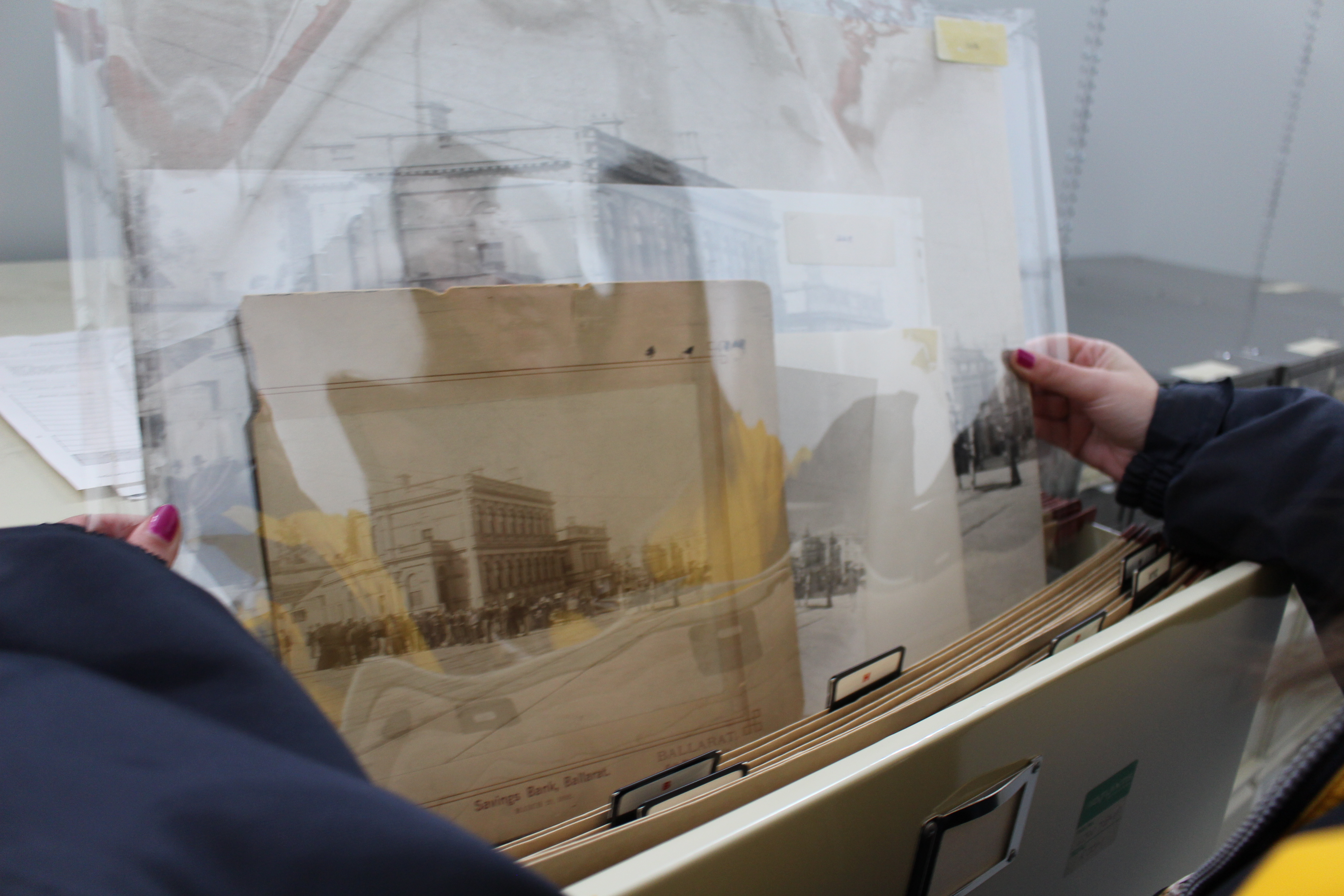 photo of photographs being pulled from a filing cabinet